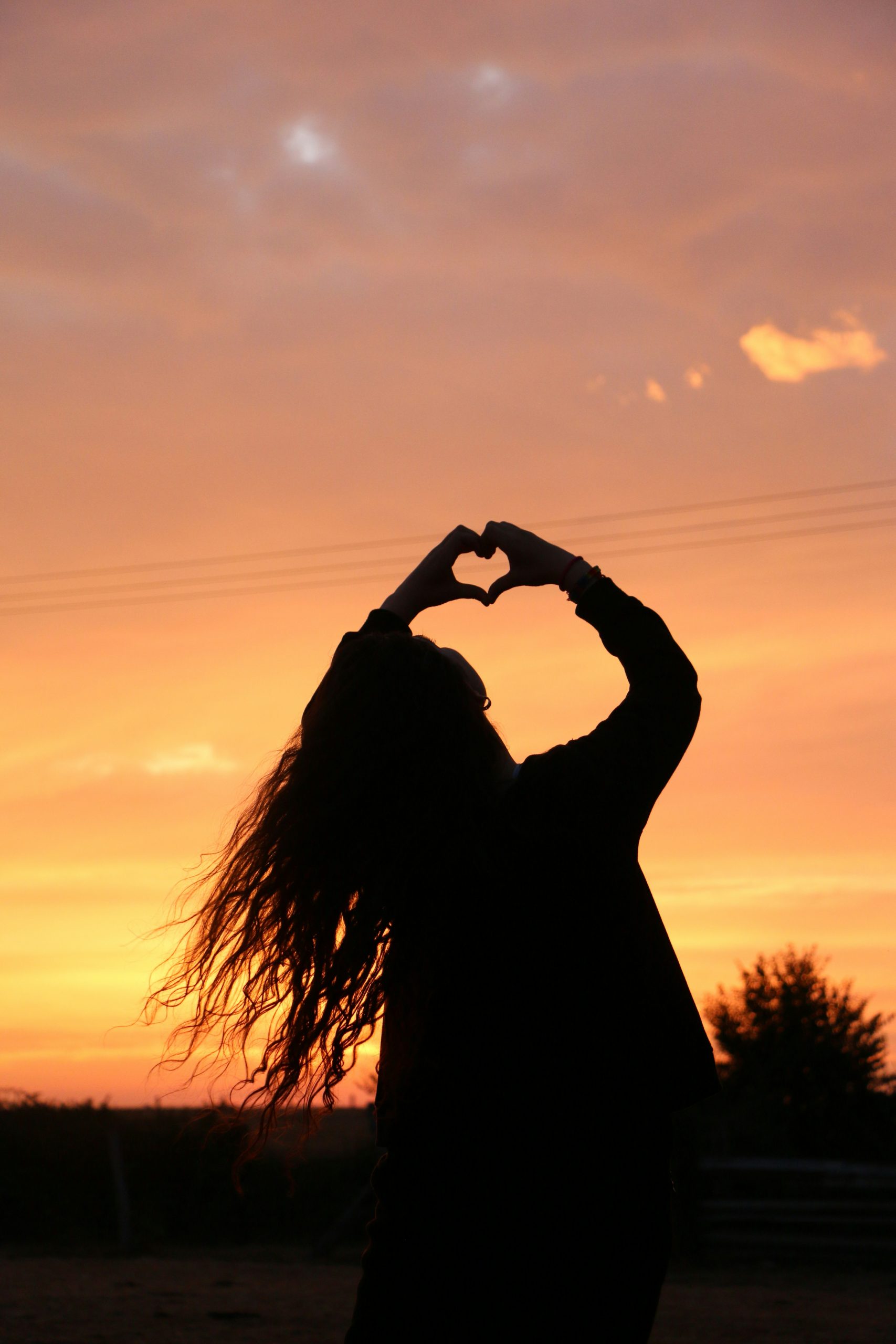 Neues Herz im Licht Liebeskummer überwinden: Herzgeste im Sonnenuntergang – Hoffnung auf neue Liebe