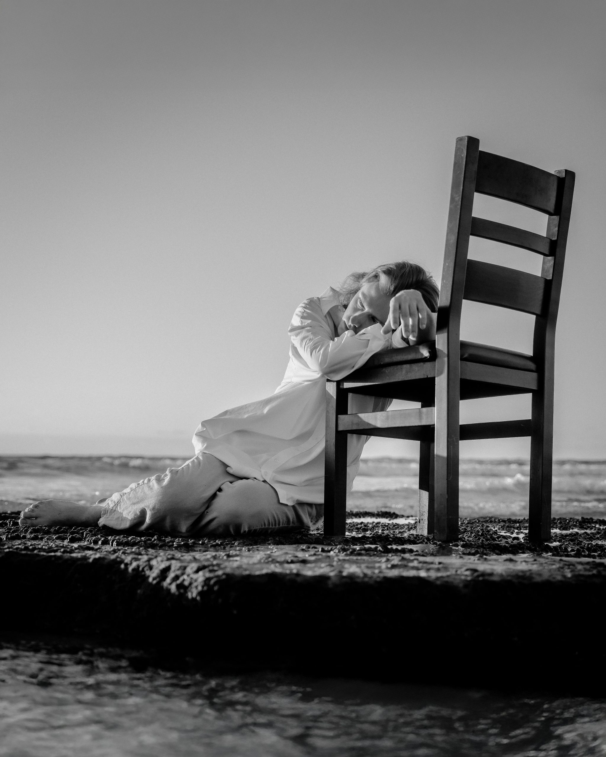 Nachdenkliche Frau am Strand als Symbol für Zweifel und Hoffnung nach einer Trennung