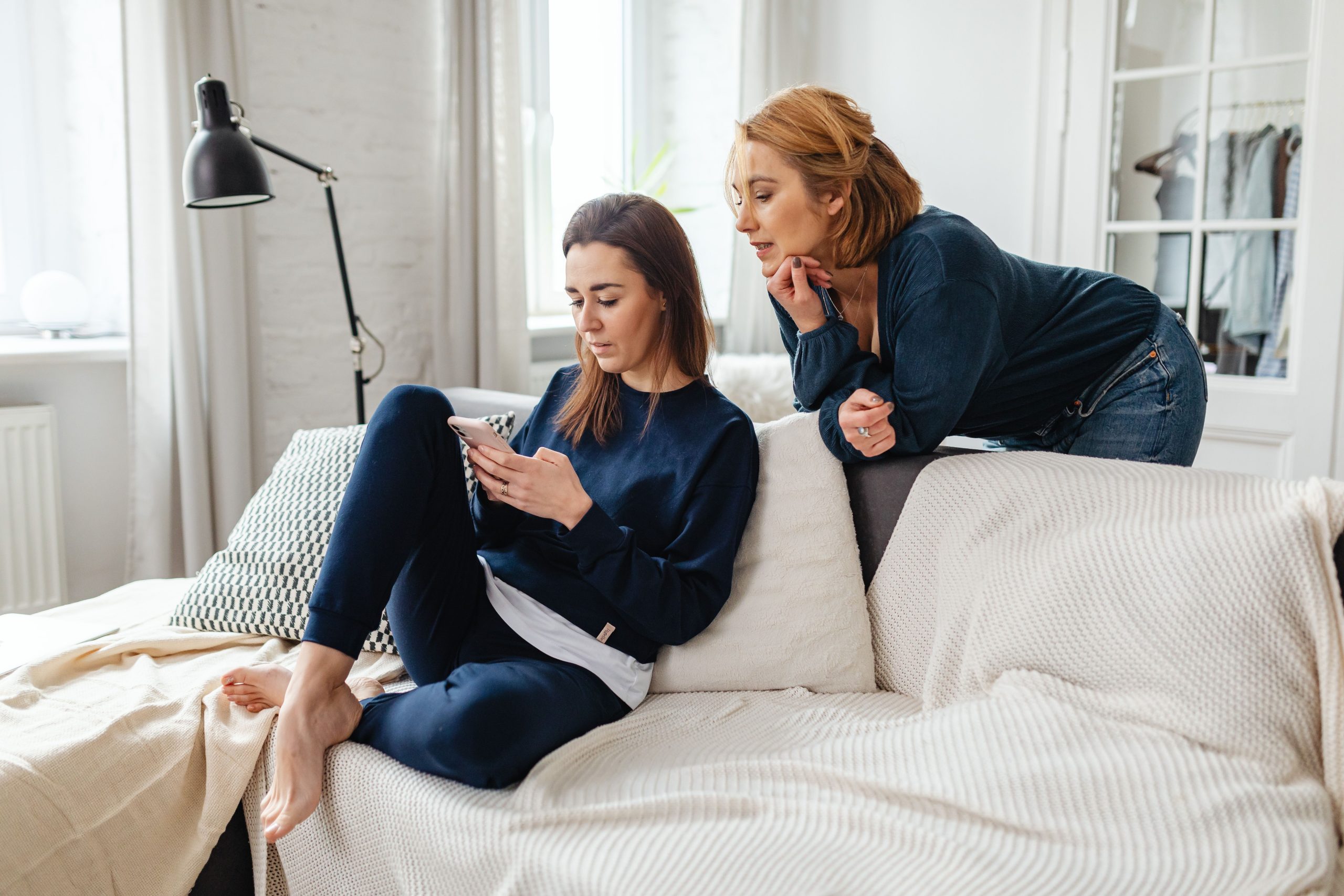 Frauen schauen auf ein Smartphone – Unsicherheit, weil der Ex eine neue Beziehung hat
