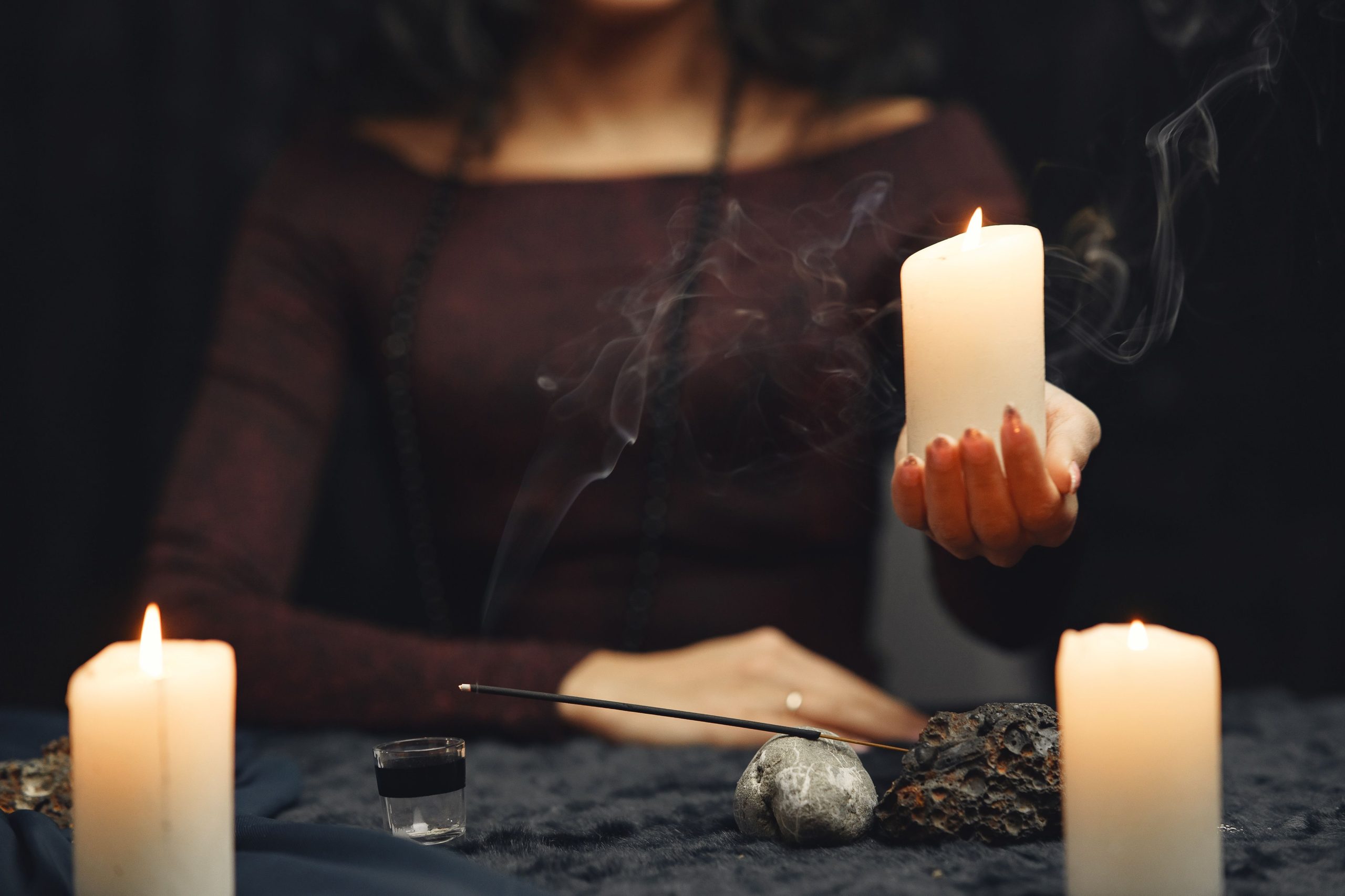 Frau mit Kerze bei Ritualarbeit als Symbol für den Ablauf einer professionellen Partnerrückführung