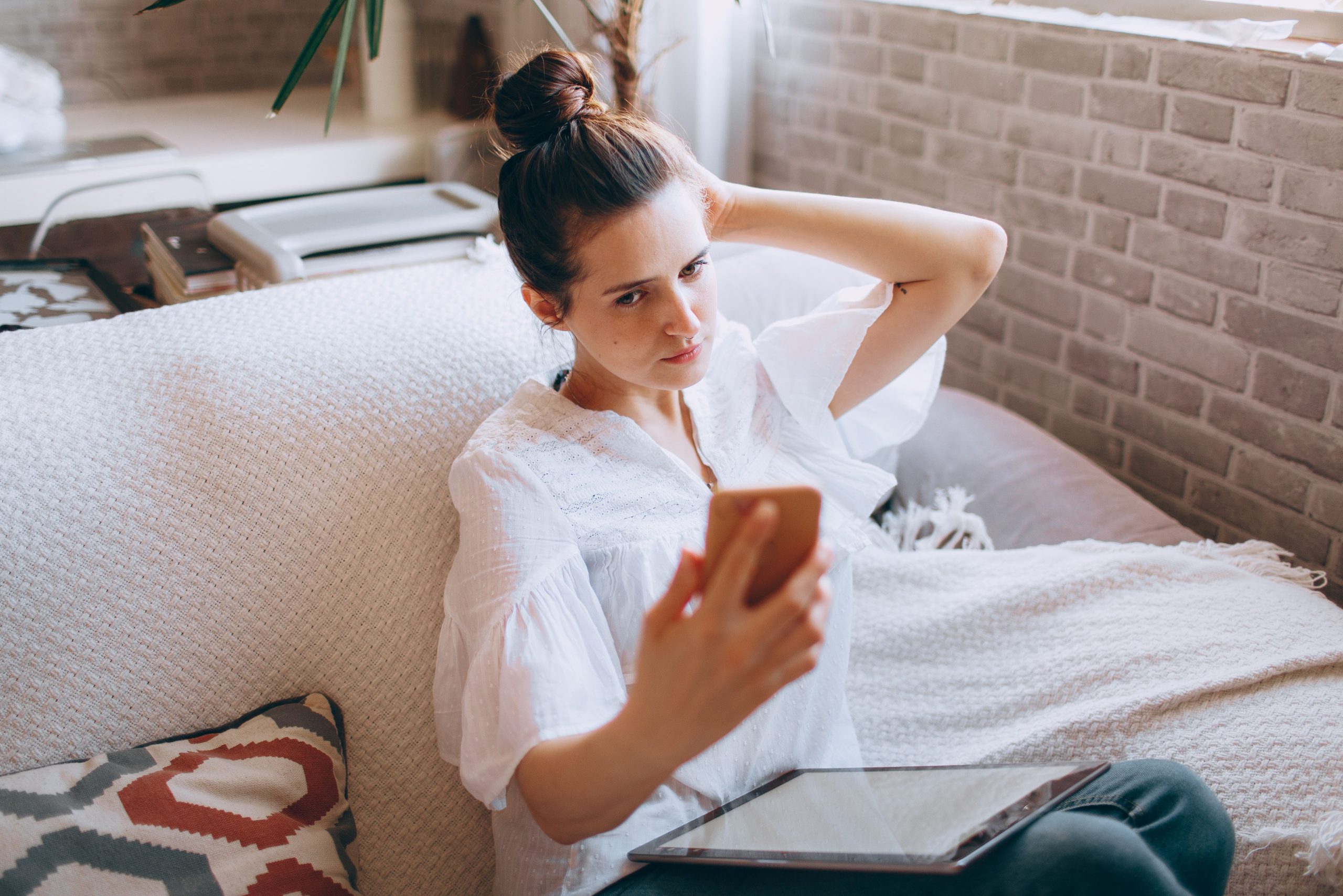 Frau liest Informationen auf Smartphone und Tablet und sucht Orientierung
